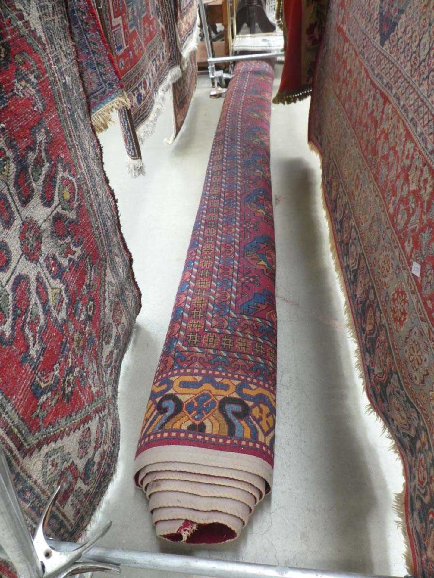 A 20th century Persian carpet, the red ground decorated with cross and star motifs, within