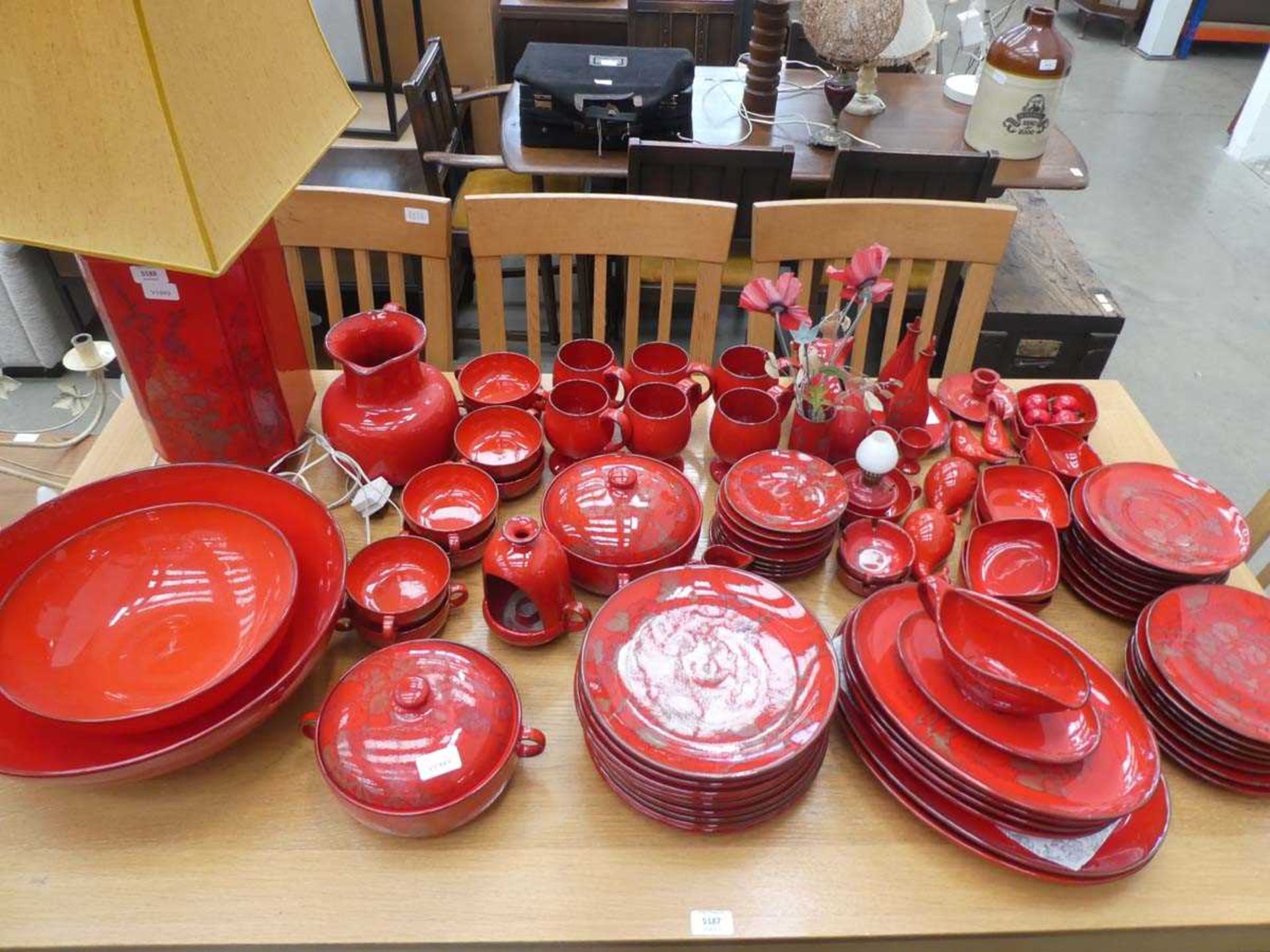 Suite of Italian Ernestine red glazed tableware, including table lamp, fruit bowl, and various other