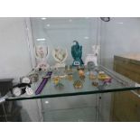Shelf of costume jewellery, bottle stoppers, prayer hand ornaments and wrist watches