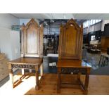 Pair of dark oak panel seated dining chairs with carved finial type tops