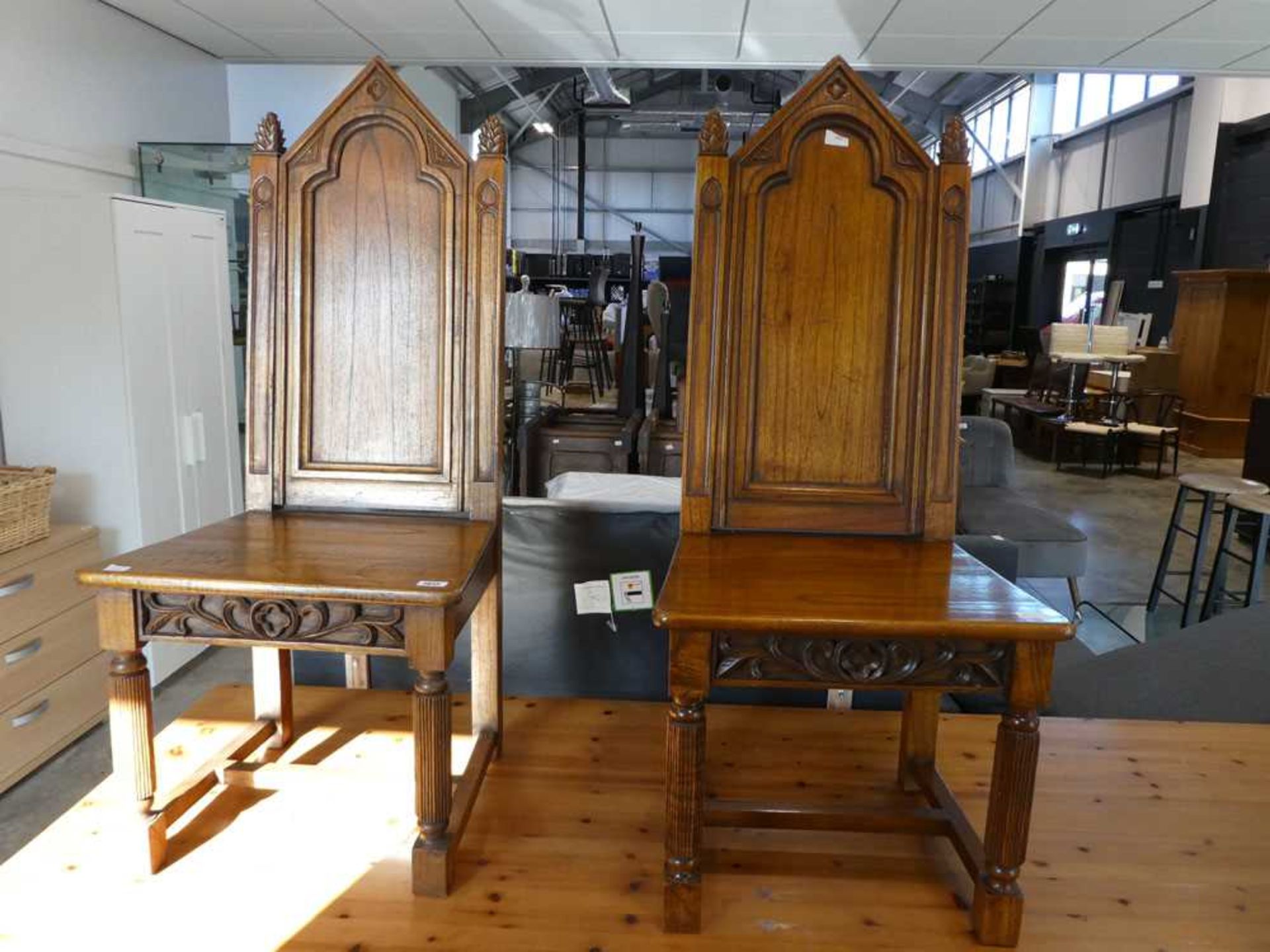 Pair of dark oak panel seated dining chairs with carved finial type tops