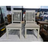 Modern pair of white slat back dining chairs with beige upholstered seats