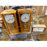 2 Comitti wall clocks in light wooden cases with rectangular London Clock Company clock