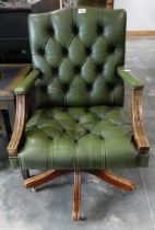 Dark green leather upholstered Chesterfield captain style swivel armchair, on wooden frame