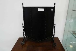 Black wrought metal solid panel fire screen in the form of a shield