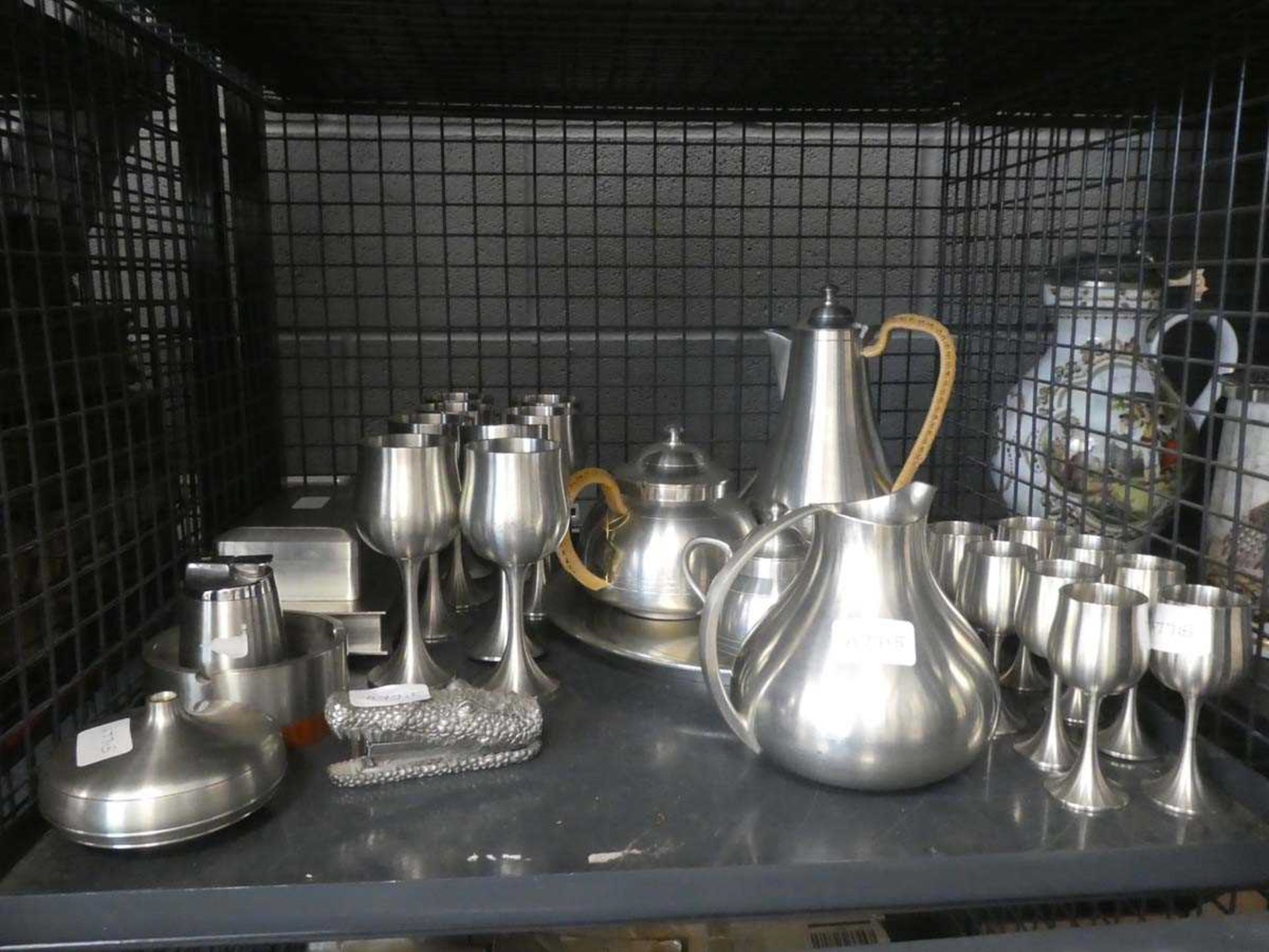 Cage containing stainless steel goblets, jug, wine glasses, table lighter, ash tray and a 4 piece