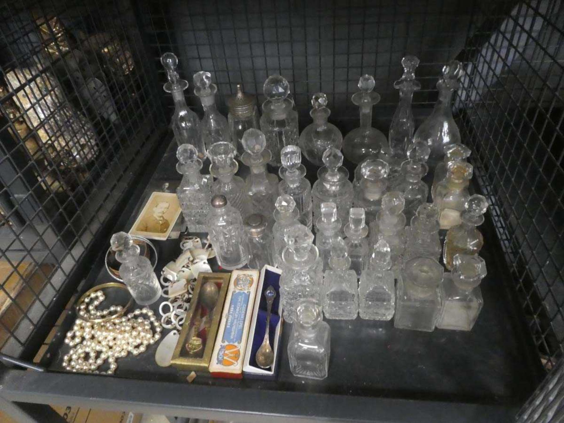 Cage containing a collection of sauce bottles plus souvenir spoons and Edwardian photo portraits