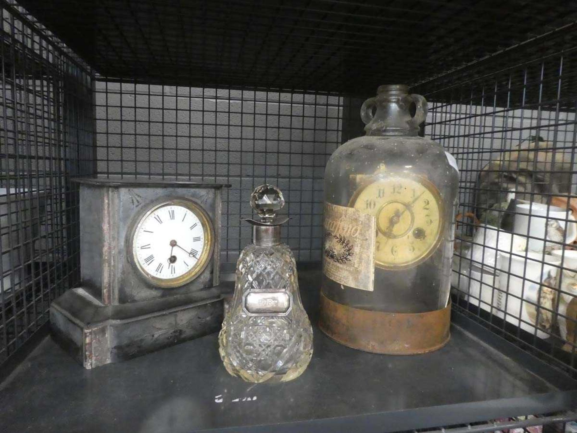Cage containing a decanter with silver collar and ladle plus 2 mantle clocks
