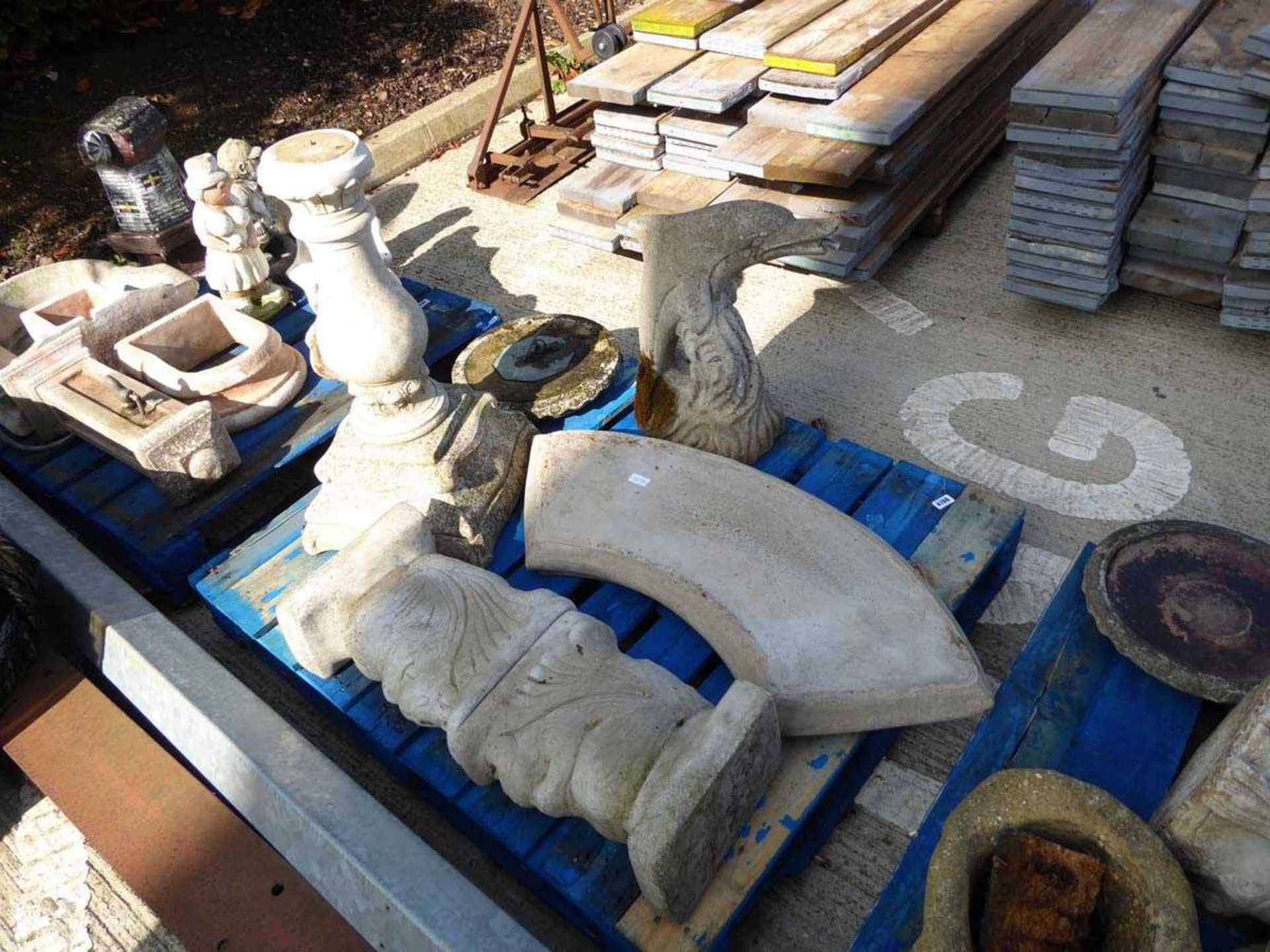 Pallet containing concrete garden bench, sun dial and dolphin