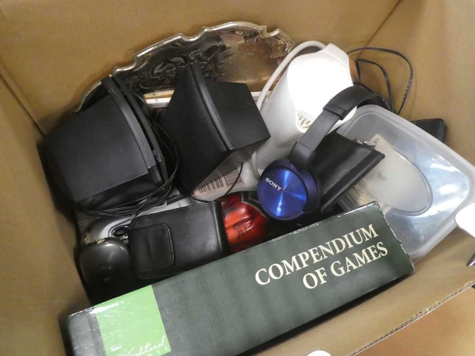 Box containing games, headphones, cigarette cards, kettle, and serving tray