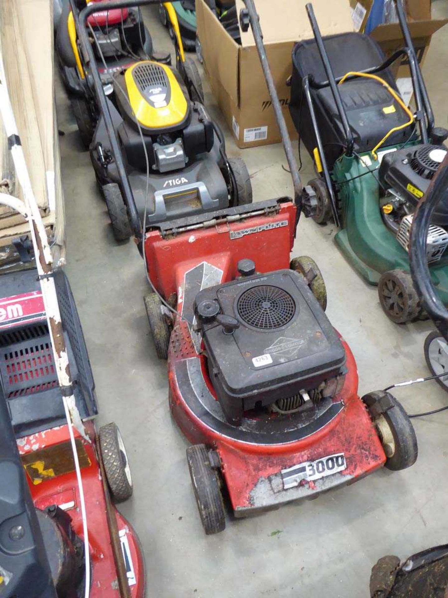 Red petrol powered rotary lawn mower, no grass box