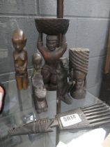 Six carved African pieces, to include figures and comb