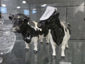 Two black and white Beswick cattle figures