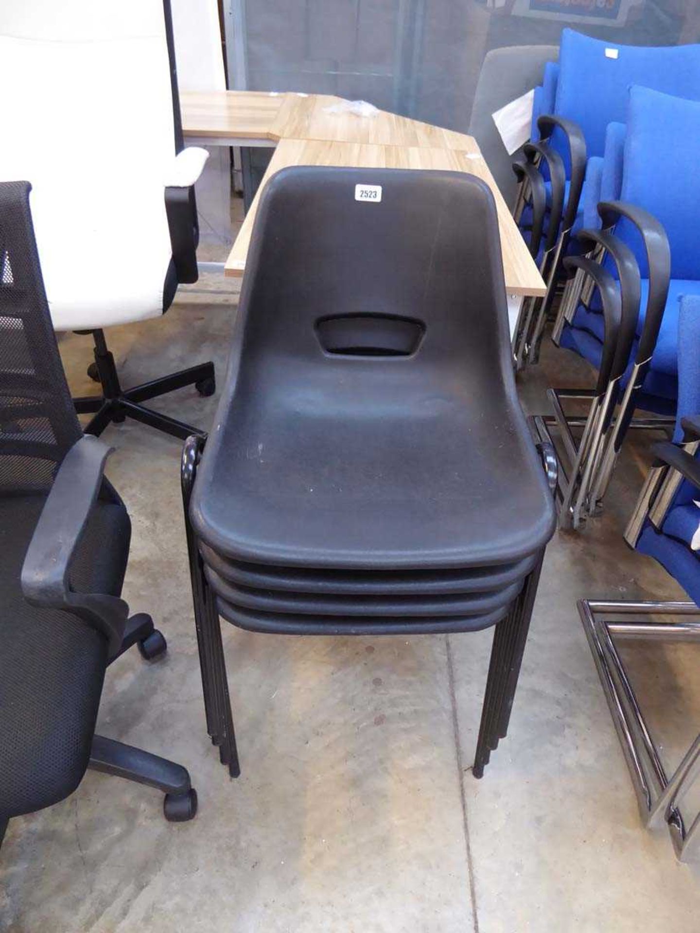 Stack of 4 black plastic stacking chairs