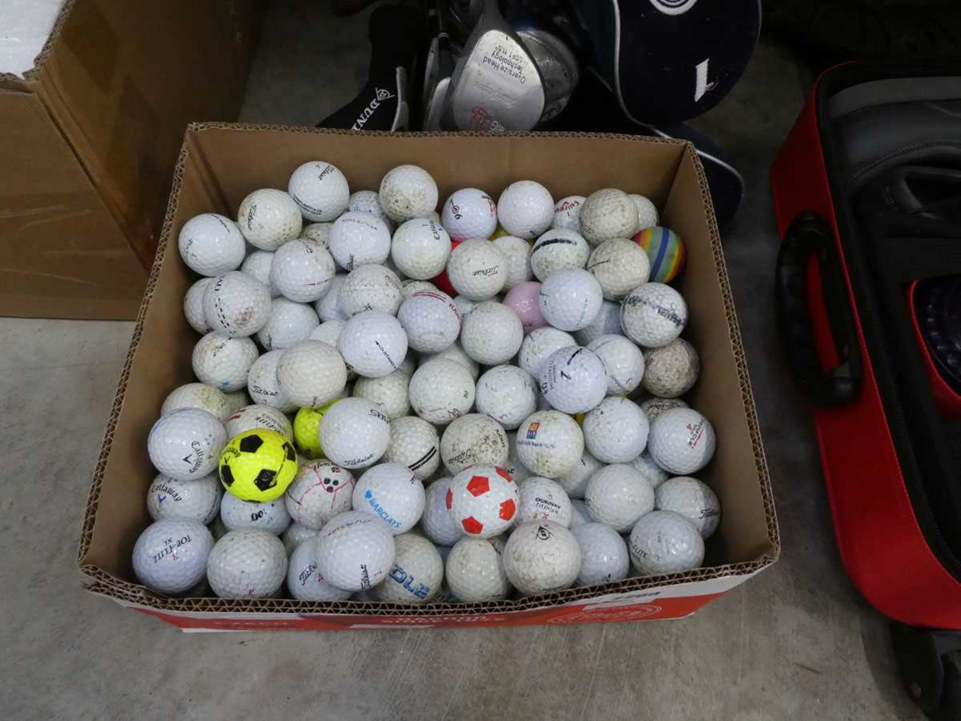 Box containing a large quantity of mixed branded golf balls