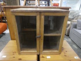 An early 20th century pine dove tailed cabinet with glazed doors