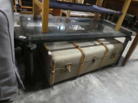 Metal based coffee table with column shaded supports and glass surface