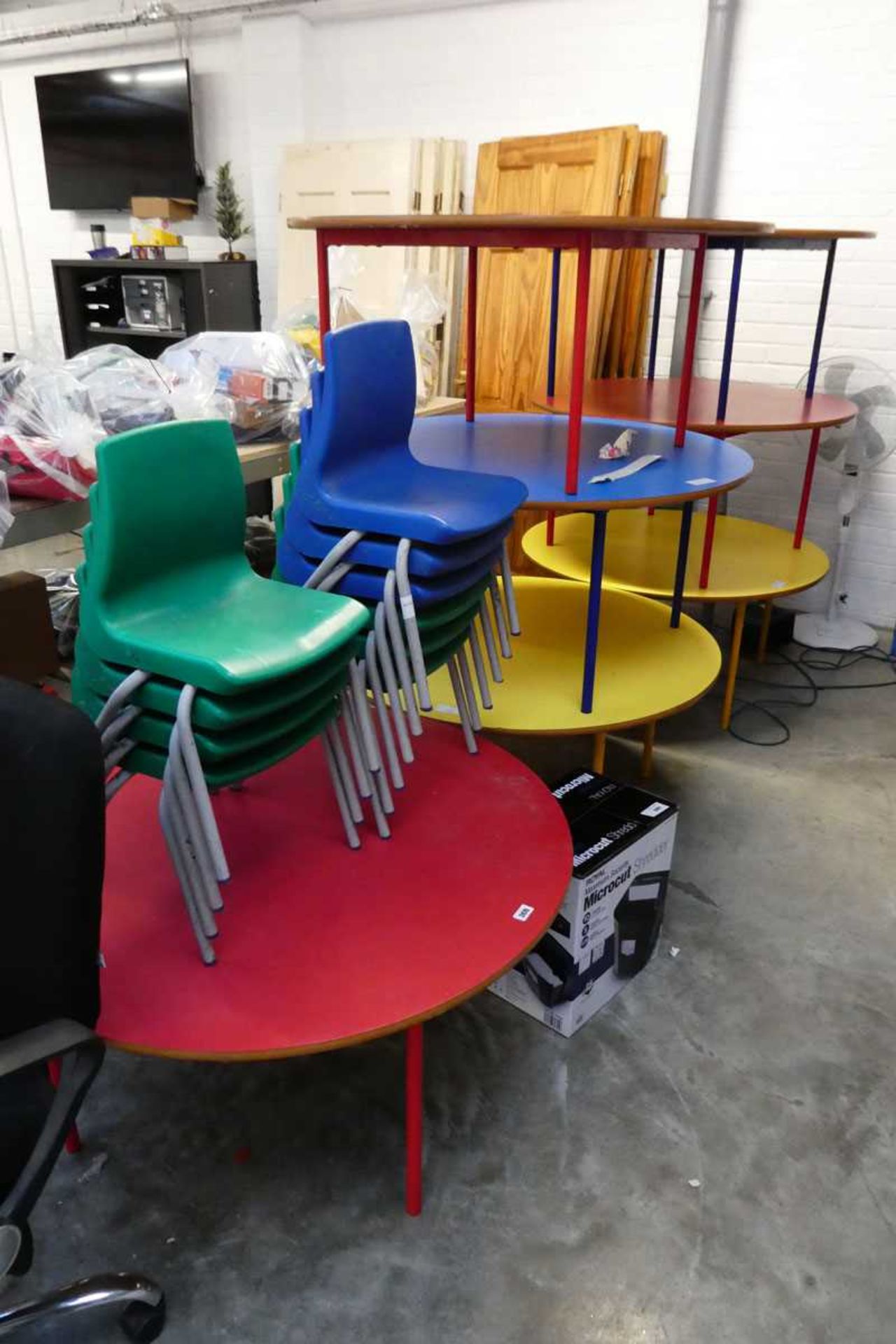 7 metal framed childrens circular tables together with 2 stacks of plastic childrens school chairs