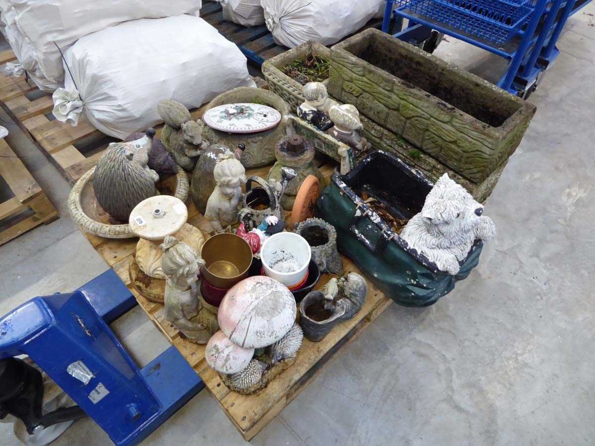 Pallet containing a large quantity of various concrete garden ornaments to include a dog planter,