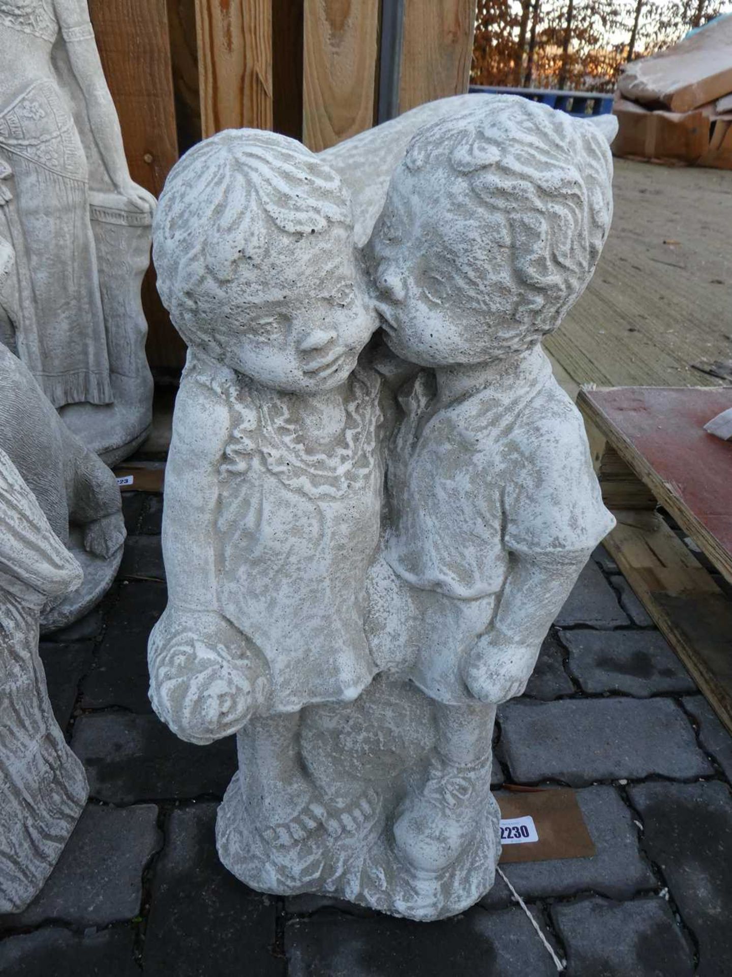 Boy kissing a girl concrete ornament