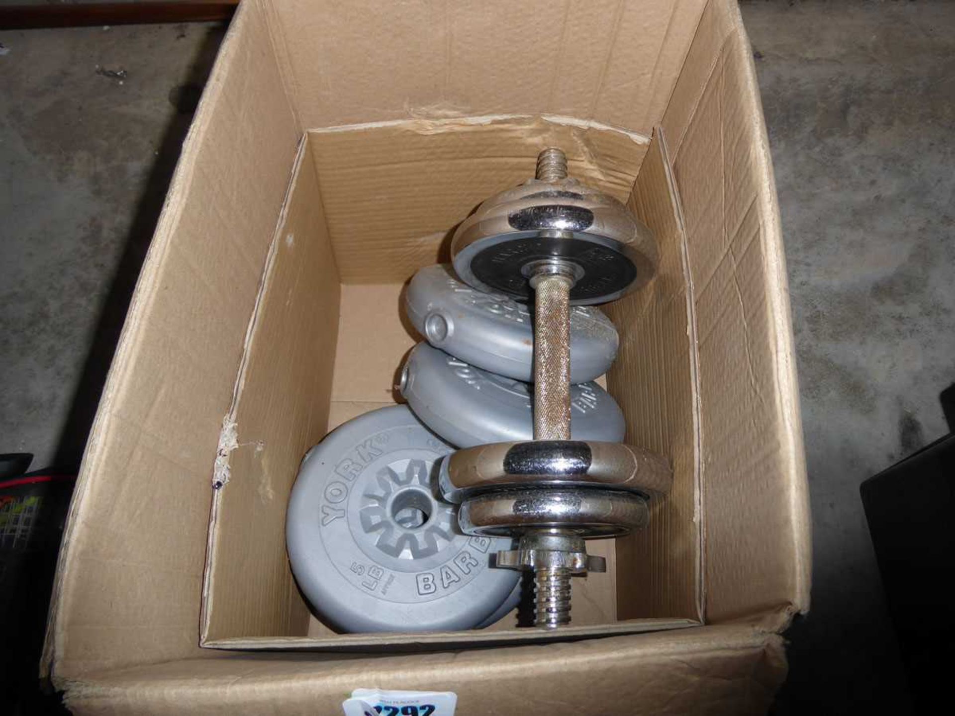 Box containing mixed size dumbbell weights