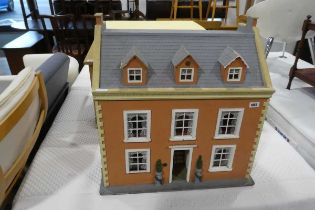 Child's terracotta coloured dolls house with front opening