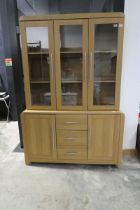 Light oak finish dining room cabinet with 3 upper glazed doors and cupboard and drawer storage