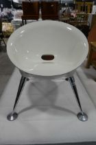 Modern bucket type chair with white plastic seat and tapered chrome supports