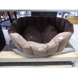 Brown semicircular dog bed with grey button back dog pillow