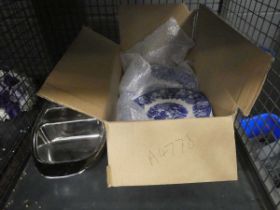 Cage containing blue and white plates and stainless steel dish