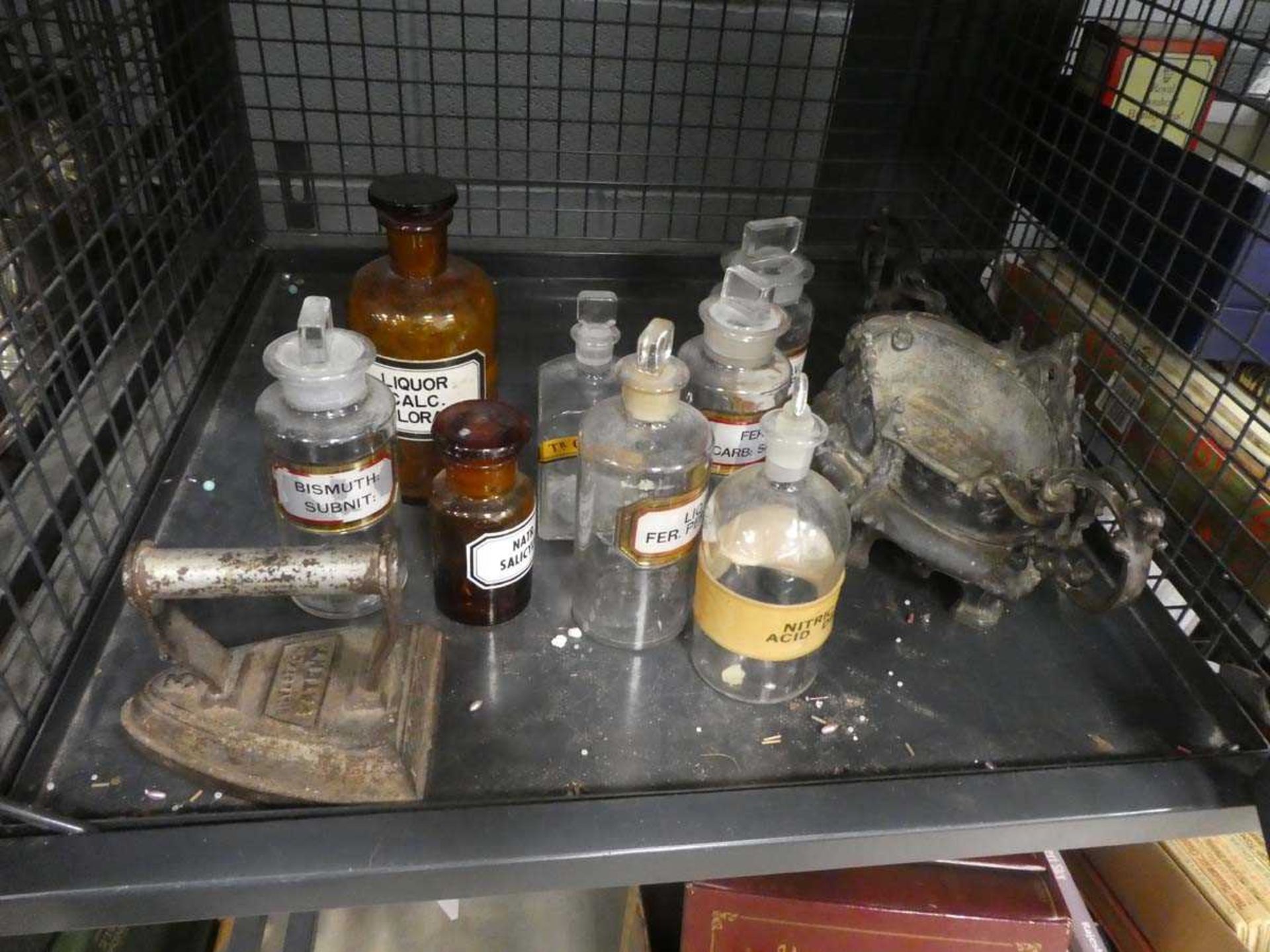 Cage containing a flat iron plus medicine bottles, and gothic pot stand