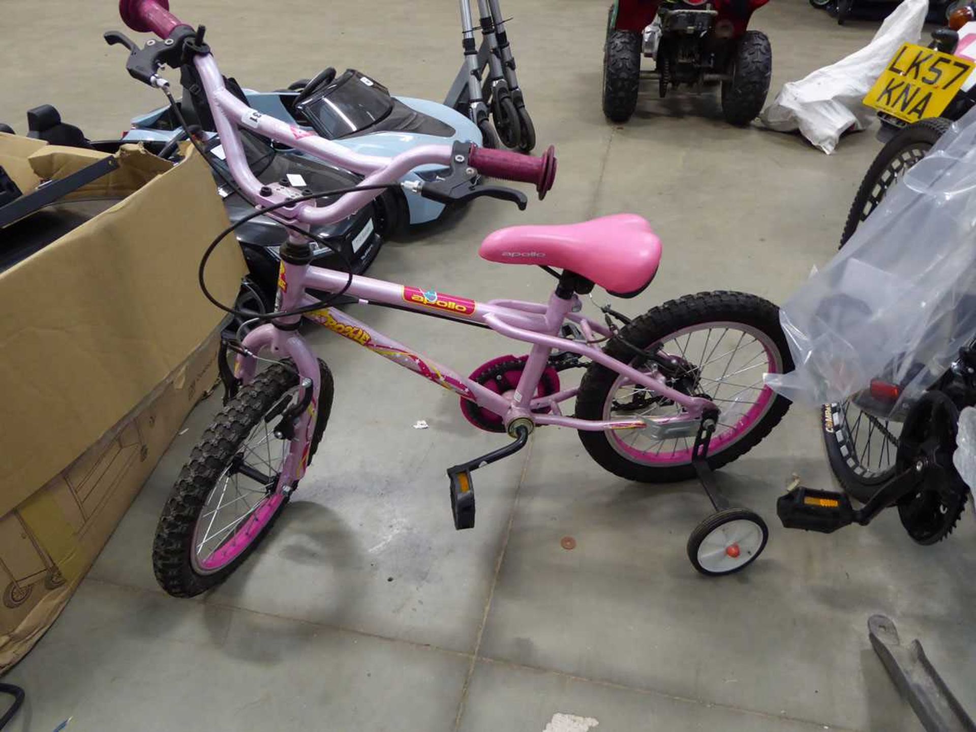 Small child's pink bike with stabilisers