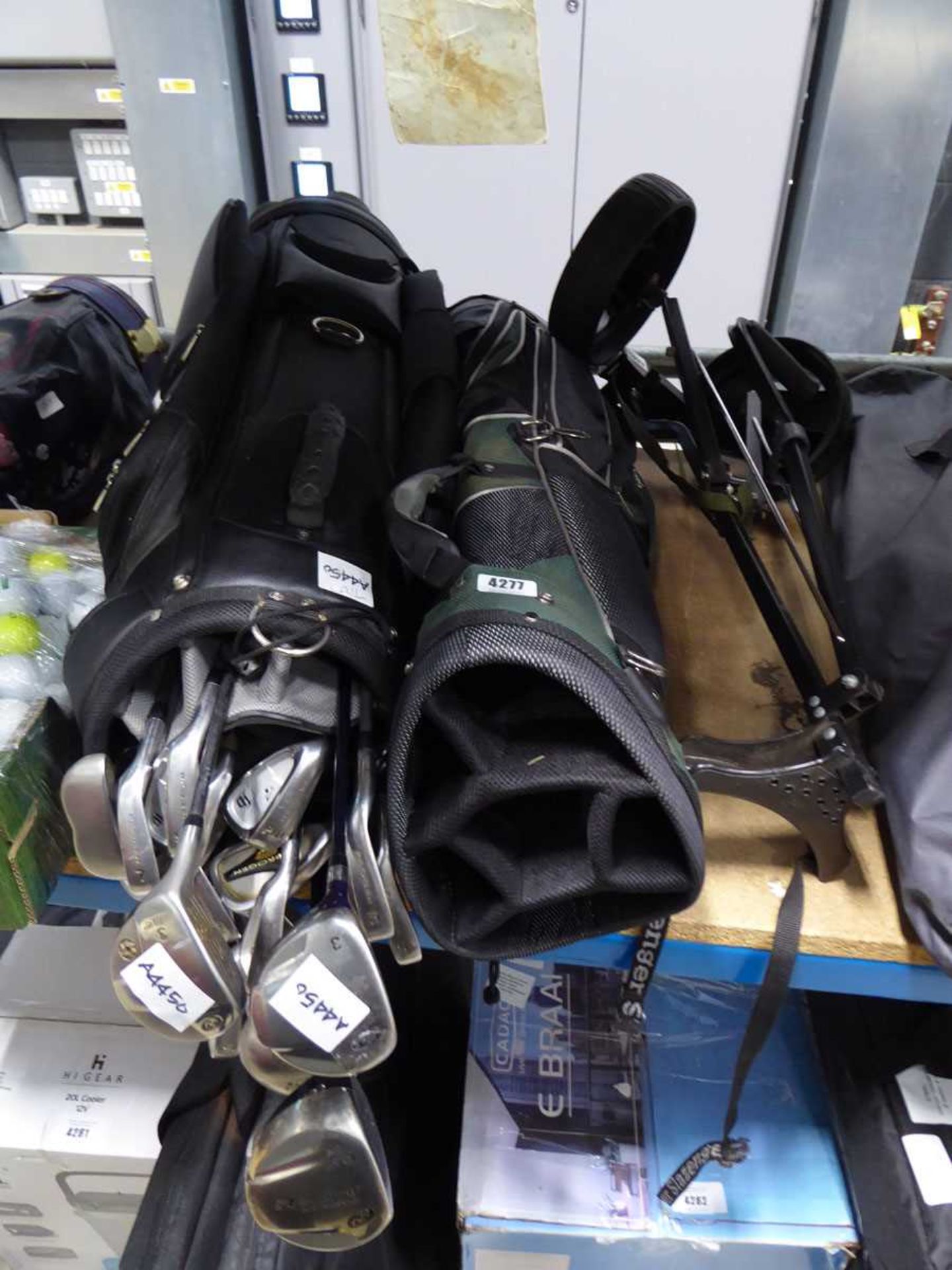 1 black and 1 green golf bag with trolley and clubs