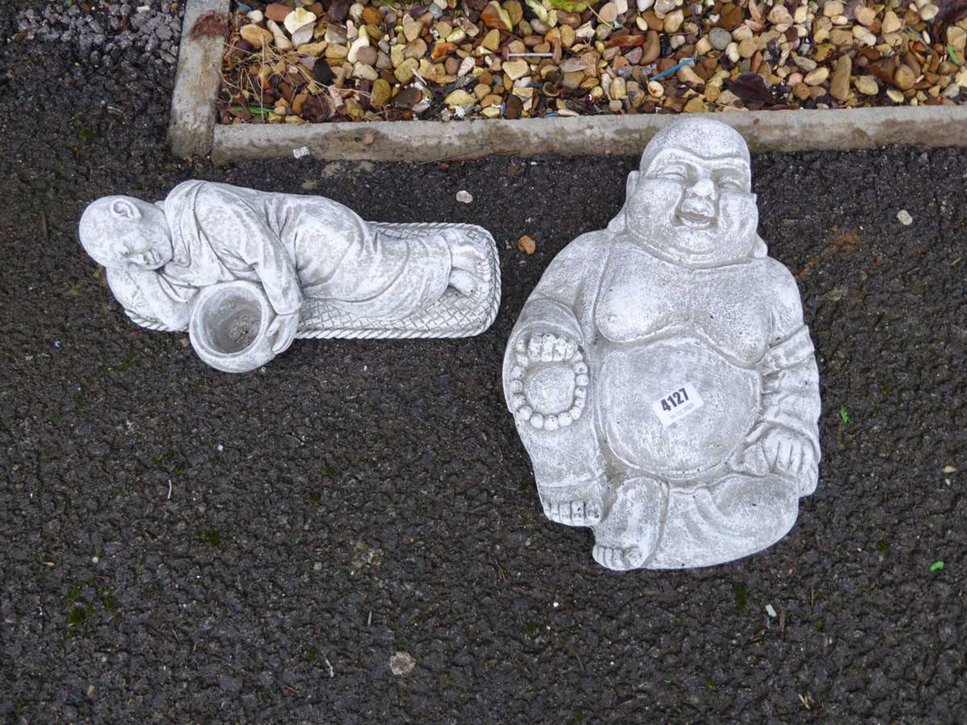 Two concrete Buddha figures, one reclining, one seated