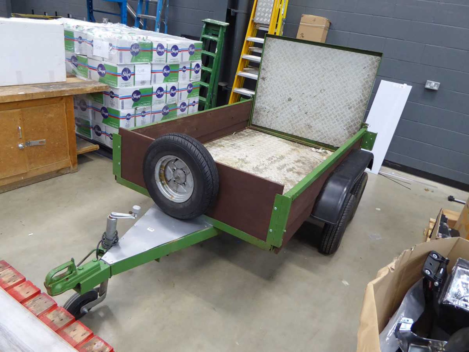 Double axle green metal and wood plant trailer with fold down backboard