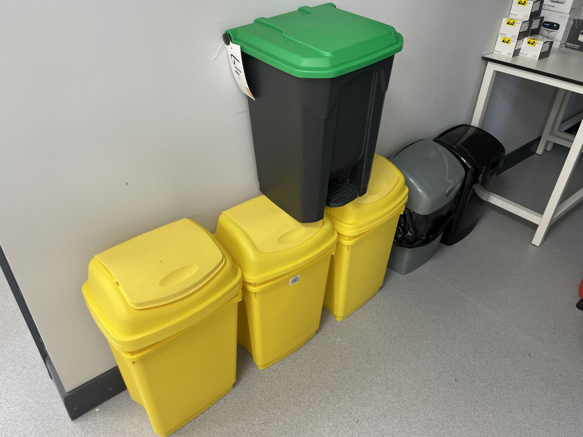 6 yellow 50 litre swing top binds with 3 other waste bins.
