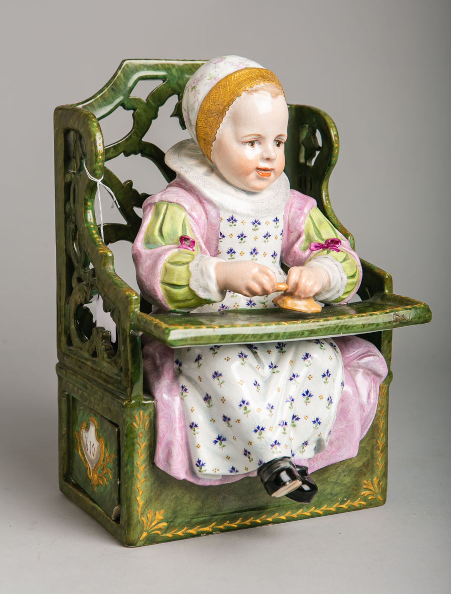 Figur "Kind auf Kinderstuhl" (St-Clement, Luneville, Frankreich, wohl 19. Jh.)