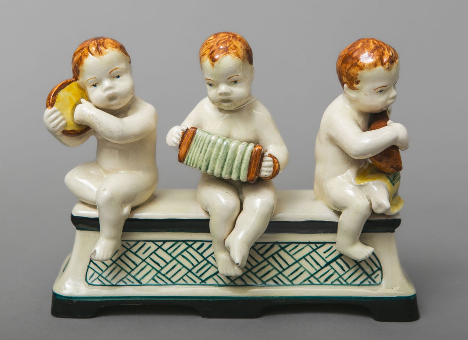 Figurengruppe "Drei nackte Knäblein auf einer Bank beim Musizieren"  (Majolika Keramik Manufaktur Ka