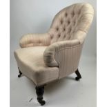 A VICTORIAN BUTTON BACK ARMCHAIR, upholstered in striped linen fabric.
