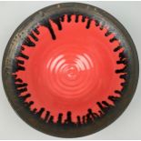 A STUDIO POTTERY CERAMIC VERMILLION GLAZED BOWL WITH BRONZED RIM, in the manner of Lucie Rie. 25.5cm