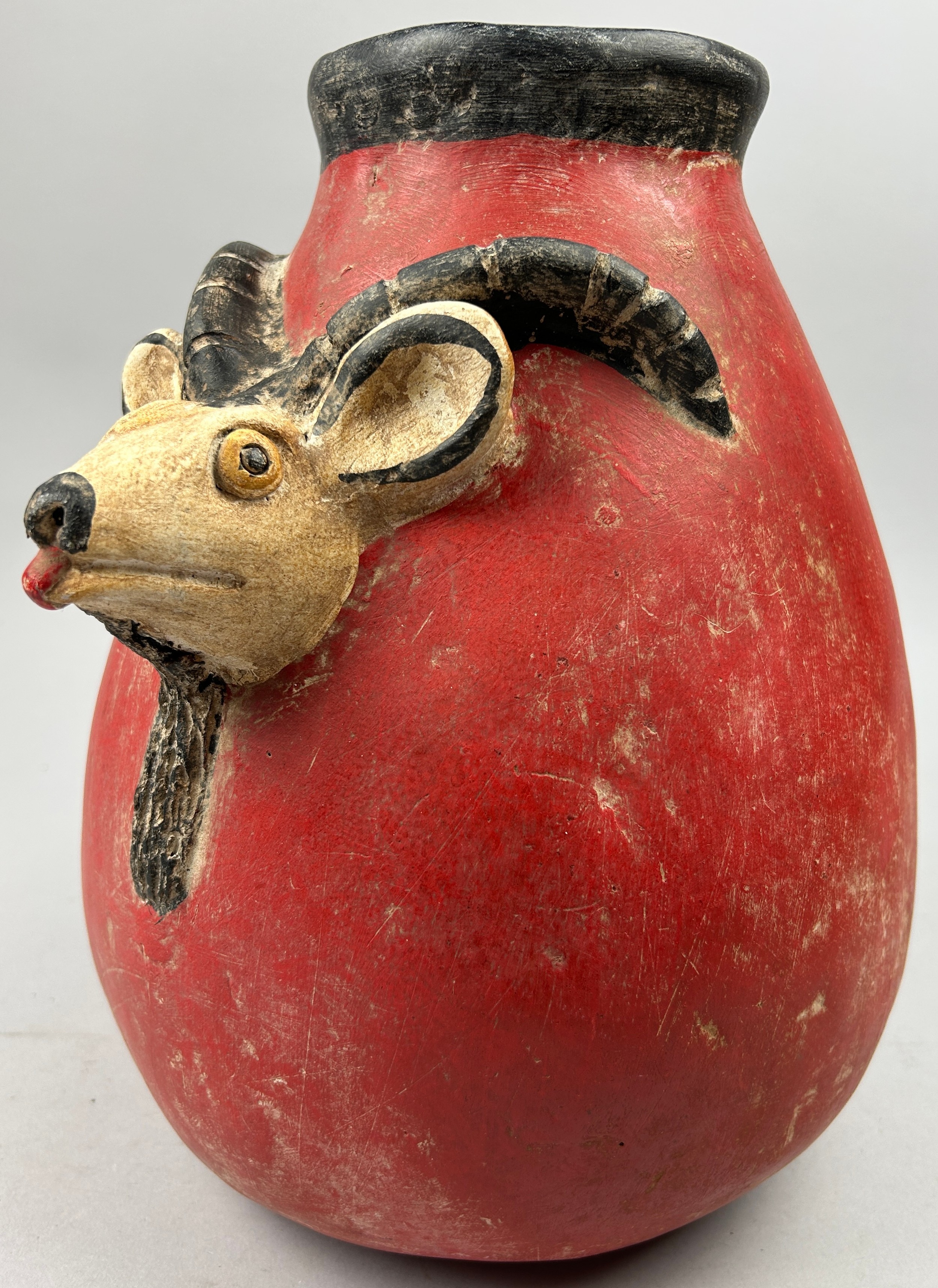 A PRE-COLUMBIAN STYLE JUG, modern after the antique with vivid red earthenware glaze and figure of a