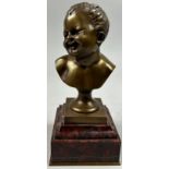 AFTER JEAN-BAPTISTE CARPEAUX 1827-1875, a bronze bust of a laughing putti, mounted on a red marble