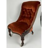 A VICTORIAN MAHOGANY NURSING CHAIR, buttoned back red velvet upholstered on turned legs and castors.