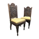 A MATCHED PAIR OF PROFUSELY CARVED INDIAN BOMBAYWOOD CHAIRS, with removable upholstered seats