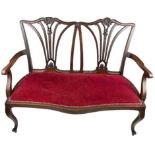 A VICTORIAN HALL SEAT, with two pierced back rails, sloping arms and upholstered in red velvet.