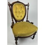 A VICTORIAN SMALL GREEN VELVET UPHOLSTERED NURSING CHAIR, on turned legs and castors 78cm x 54cm