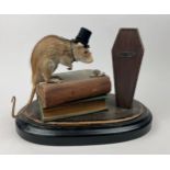 ANTHROPOMORPHIC TAXIDERMY RAT, mounted on books with coffin