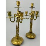 A PAIR OF GILT-METAL CANDELABRA, with three arms mounted on circular bases, raised on roundels.