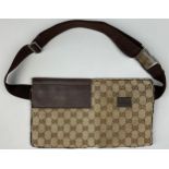 A GUCCI BELT BAG WITH INTERLOCKING MONOGRAM DESIGN, Outer zipped compartment, and brown strap.