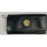 A VERSACE BLACK LEATHER WALLET, with gold coloured hardware